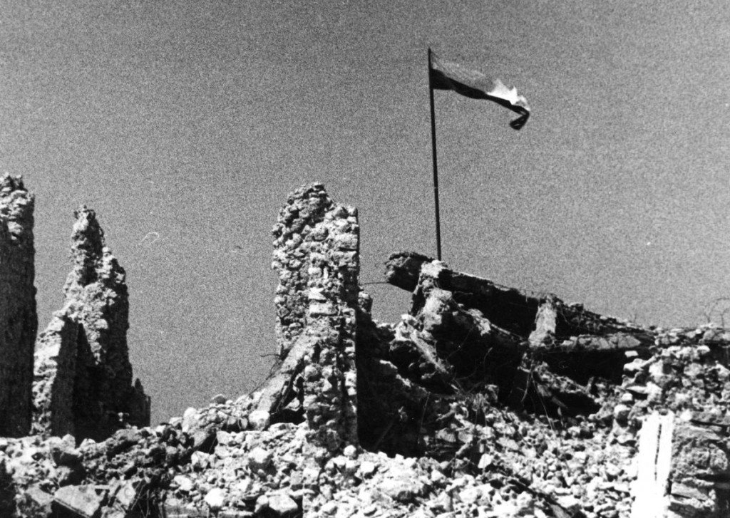 the polish flag being raised over monte cassino